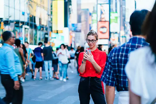 Subscriber using a smartphone in a busy city street